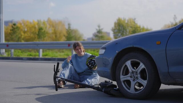 A Caucasian woman on a scooter after being hit by a car.