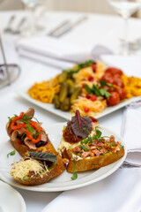 A variety of bruschetta on a plate, served on a festive holiday table