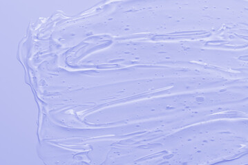 Transparent cosmetic cream gel on a lilac background. Abstract violet background.