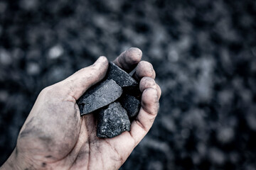 Black coal in hand. Thermal energy industry. Heating. Mineral raw materials. Natural energy stones.