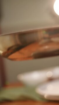 A pan is sitting on a table with a green cloth underneath it. The pan is silver and has a shiny surface