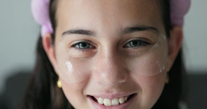 Female kid using beauty eye patches - Cosmetic, childhood and teenager lifestyle concept 