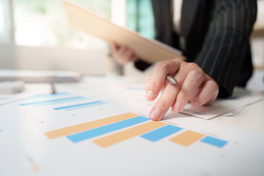 Financial Analysis. Business professional pointing at growth charts.