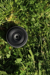 Camera Lens Placed on Grass Outdoors