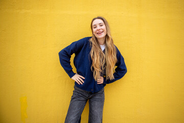 Portrait smiling woman standing by yellow background