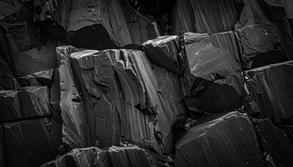 Close Up of Dark Volcanic Basalt Columns in Harsh Lighting Showing Angular Rock Formations and Rough Texture Displaying Natural Geological Patterns