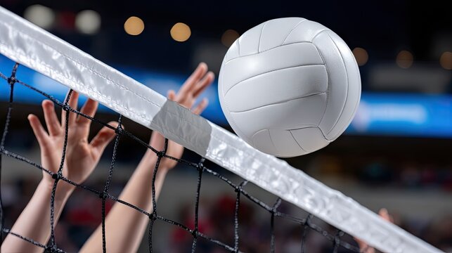 Volleyball hits the net during an intense match in a packed indoor arena filled with cheering fans and bright overhead lights