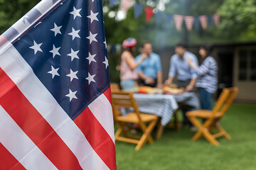 American flag in foreground celebrating a backyard barbecue with family and friends outdoors