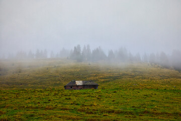 Mountain landscape with a wooden sheepfold abandoned in the Bucegi Mountains, Romania on a cloudy September day