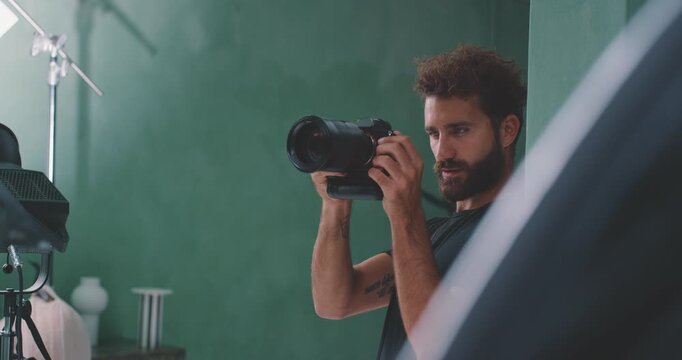Photographer taking photo, side view between studio lights