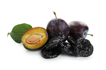 Dried prunes, fresh plums and green leaf isolated on white