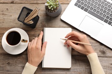 Woman drawing sketch at wooden table, top view