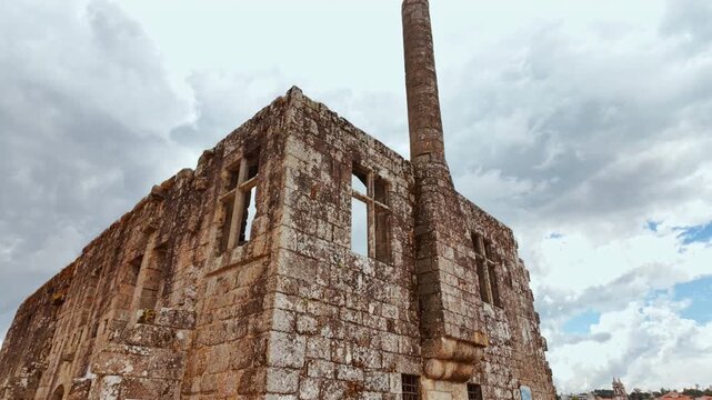 The ruins of the Paco dos Condes de Barcelos Palace reveal broken stone galleries ivy draped arches and a medieval window traceried against the sky in Barcelos, Portugal