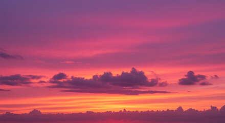 Naklejka premium Vibrant magenta sunset sky with soft clouds and glowing horizon.