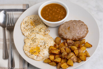 eggs over easy  with sausage patty and baked beans
