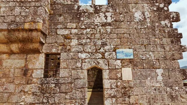 The ruins of the Paco dos Condes de Barcelos Palace reveal broken stone galleries ivy draped arches and a medieval window traceried against the sky in Barcelos, Portugal