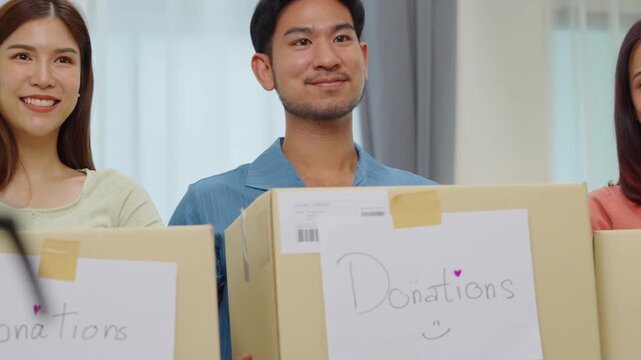 group of asian young adults tanding together, each holding a donation box with a handwritten sign. community support, and charitable giving