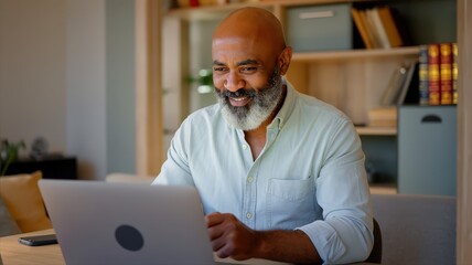 Senior man in a blue shirt expressing frustration while working on a laptop at home. The man appears to be looking for a solution or dealing with a technical problem