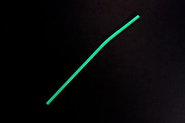 Single Green Flexible Drinking Straw on Black Background