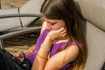 Beautiful young girl using her cell phone in the garden