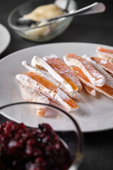 Candied orange slices on a white plate with other food items.