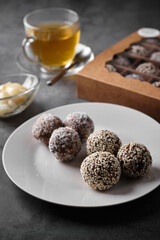 Delicious energy balls served with tea and honey on a dark background.