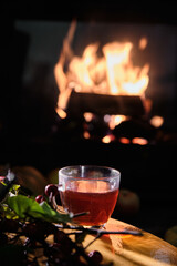 Cozy evening scene with a warm drink by the fireplace