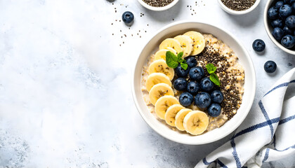 Healthy oatmeal bowl topped with fresh banana slices, blueberries, and chia seeds served in a minimal modern style.