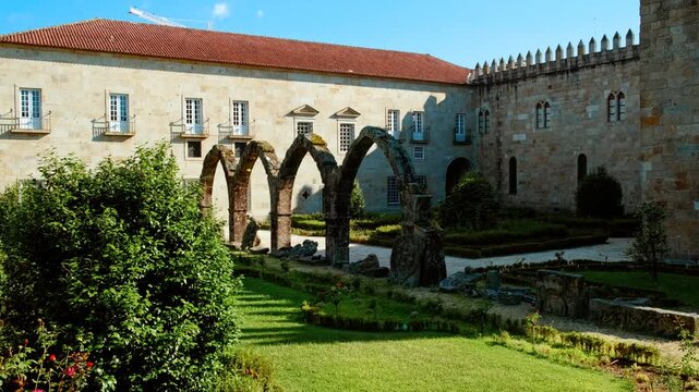 Santa Barbara Garden flourishes beside the crenellated battlements of Braga Castle with bright parterres framing Gothic arches in Braga, Portugal