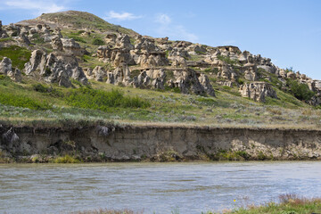Natural landscape of a river and a hill of hoodoos on the the far bank.