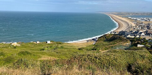 Chesil beach stretching around Lyme Bay in Dorset with Portland harbour on the left hand side