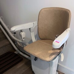 A stair lift or chair lift at the bottom of the stairs in a home. Used to help people with dissabilities, the elderly and those prone to falling to go upstairs and downstairs in their homes.