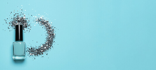 Nail polish bottle with glitter confetti flat lay, cosmetic display on ice blue background