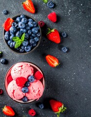 Fresh berry ice cream bowls on dark stone