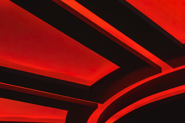 Red illuminated ceiling design with glowing geometric lines in a dark interior. Concept of cinema,...