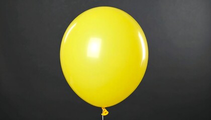 Single bright yellow balloon against dark background