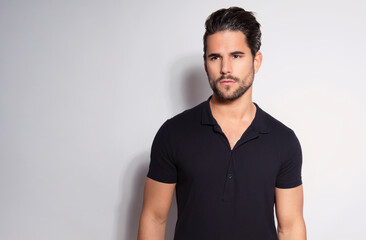 Fototapeta premium Handsome young man with dark hair and beard posing in casual clothes