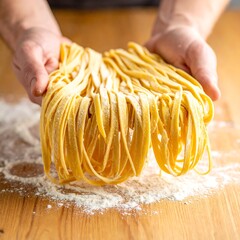 Hands hold fresh pasta noodles dusted with flour