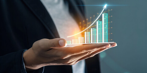 Hand holding glowing holographic financial growth chart with rising arrow showing success