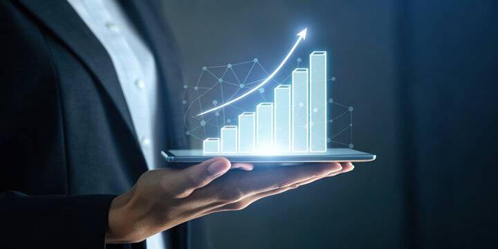Businessman holding digital tablet with glowing rising bar chart and arrow showing growth