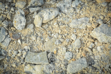 a varied texture of gray and white rocks, small pebbles, and yellowish sandy soil, ideal for construction-themed designs.