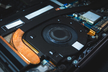 Close-up image of an all-in-one computer interior showing the motherboard, heat pipe cooling system, RAM slot, processor, and electronic components. Inside View of All-in-One Computer Motherboard