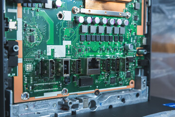 Close-up image of an all-in-one computer interior showing the motherboard, heat pipe cooling system, RAM slot, processor, and electronic components. Inside View of All-in-One Computer Motherboard