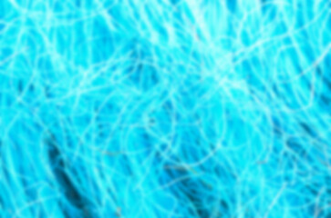 This abstract background features a heavily blurred composition of glowing, energetic lines in a vibrant turquoise and cyan palette, symbolizing modern technology.