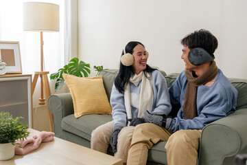 Obraz premium Winter cold brings happy couple together inside home, people enjoy warm moments, love fills air for cozy family, earmuffs and scarves provide comfort on relaxing winter day