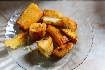 Delicious fried yucca pieces are artfully arranged, showcasing their golden-brown crusts and soft interiors. Isolated on a white background to highlight their texture and appetizing appeal.