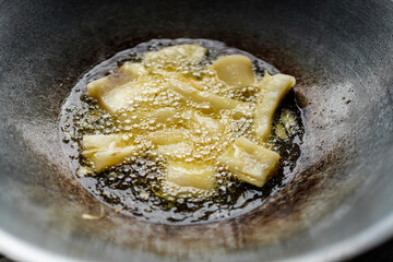 Capture the crispy sizzle with this image of food frying in hot oil, perfect for recipes and culinary projects. This culinary moment adds authentic detail to your isolated in white background.