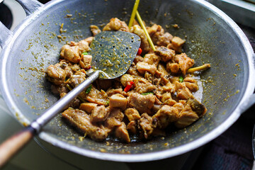 Savory cooked meat with vegetable and sauce on pan, accompanied by a metal spatula. Perfect for culinary projects, recipes, or food related themes, isolated in white background.