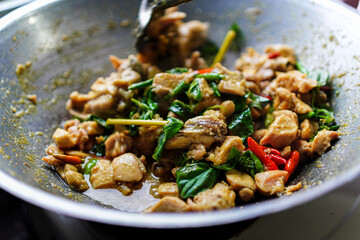 Stir-fried chicken with basil featuring vibrant red chilies, lush green basil leaves, and savory chicken pieces, offering an authentic and flavorful isolated in white background culinary experience.
