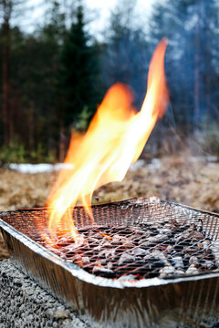 Disposable barbecue with fire flame outdoors